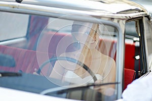 Beautiful young bride portrait in a wedding car