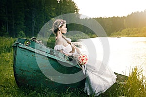 Beautiful young bride sitting on boat