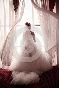 Beautiful young bride standing beside a wind