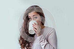 Beautiful young brunete woman with take away paper coffee cup  on white background. Happy smiling girl having lunch break