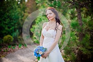 Beautiful young brunette bride in a white wedding dress with curtains, holding bouquet Ukraine