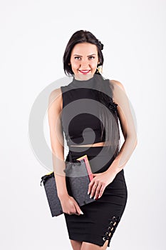 Beautiful young brunette business woman holding folders and smiling