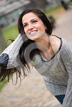 Beautiful young brunette girl smiling outdoors