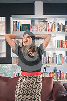 Beautiful young brunette posing in a bookstore