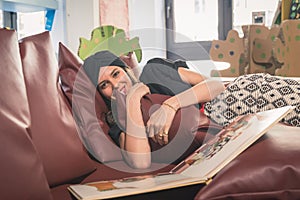 Beautiful young brunette reading book in a bookstore