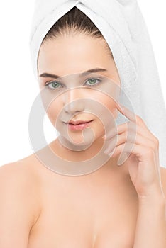 Beautiful young brunette woman with clean face and towel on her head. Isolated.