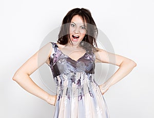 Beautiful young brunette woman in a colorful dress posing and expresses different emotions. disturbance, anger. close-up