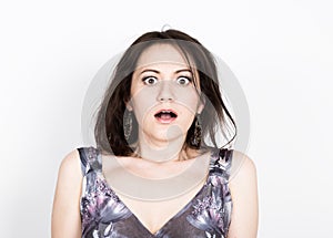 Beautiful young brunette woman in a colorful dress posing and expresses different emotions. girl's hands shows various