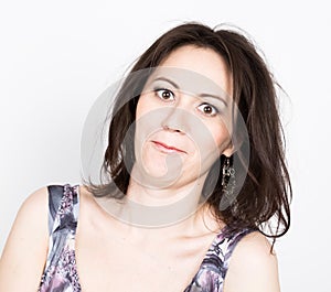 Beautiful young brunette woman in a colorful dress posing and expresses different emotions. girl's hands shows various