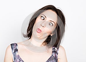 Beautiful young brunette woman in a colorful dress posing and expresses different emotions. girl's hands shows various