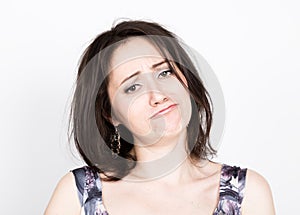 Beautiful young brunette woman in a colorful dress posing and expresses different emotions. girl's hands shows various