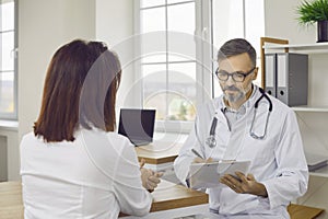 Beautiful, young brunette woman at doctor's appointment in the office of the clinic of modern medical center.