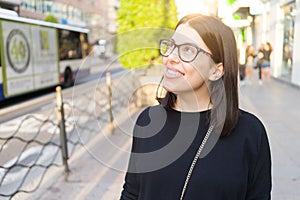 Beautiful young brunette woman smiling excited walking down the city streets, happy and confident expression standing outdoors at