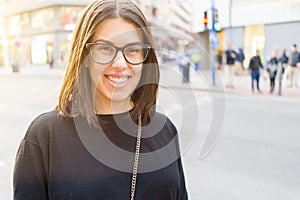 Beautiful young brunette woman smiling excited walking down the city streets, happy and confident expression standing outdoors at