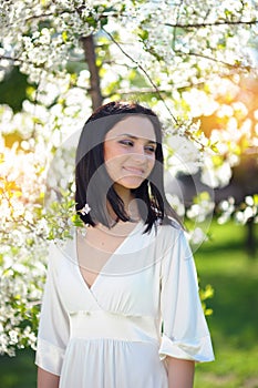 Beautiful young brunette woman in a spring park laughing