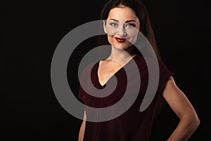 Beautiful young business toothy smiling woman thinking and looking happy in burgundy blouse and with red lipstick on dark shadow