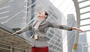 Beautiful young business woman feeling free with arms wide open outside