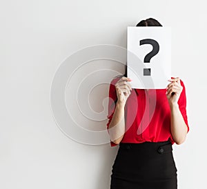 Beautiful young business woman holding a question mark