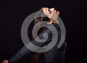 Beautiful young business woman relaxing and stretching in blue shirt isolated on black background with empty copy space. Closeup.
