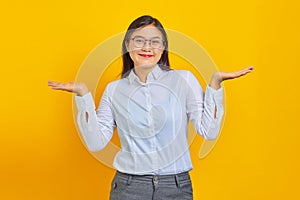 Beautiful young business woman smiling with confident face showing copy space with palms on yellow background