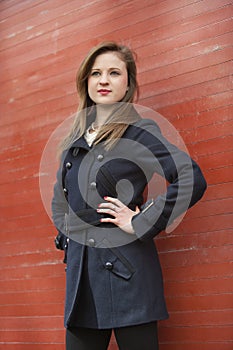 Beautiful young business woman standing with hands on hips looking away