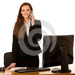 Beautiful young business woman talks on the phone in her office