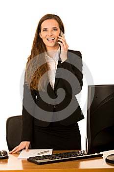 Beautiful young business woman talks on the phone in her office