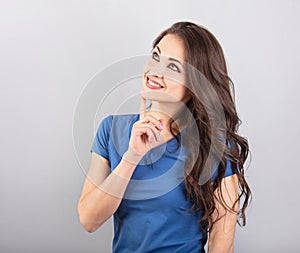 Beautiful young business woman thinking and looking up on blue background in blue clothing