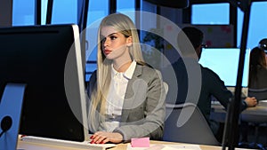 Beautiful young business woman working with computer while sitting in desk in modern startup office.