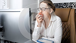 Beautiful young businesswoman biting red apple during lunch break