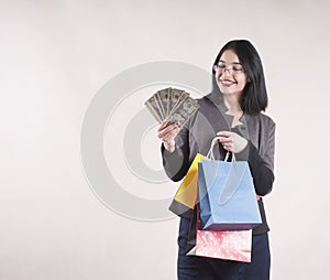 Beautiful young businesswoman brunette glasses packages for shopping studio, dollars