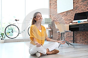 Beautiful young businesswoman doing yoga