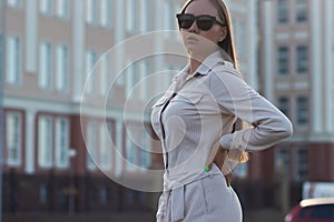 Beautiful young businesswoman standing in the city street