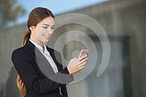 Beautiful young businesswoman is using an application in her smart phone device to send a text message