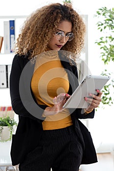 Beautiful young businesswoman using her digital tablet in the office.