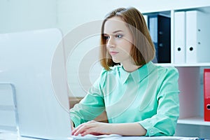 Beautiful young businesswoman working on a computer in the office. Business, exchange market, job offer, analytics