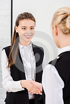 beautiful young businesswomen shaking hands