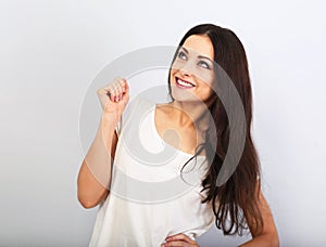 Beautiful young casual cute smiling woman on blue background looking up and thinking. Closeup portrait