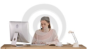 Beautiful young casual woman wearing headset working on computer on white background.