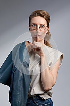 Beautiful young caucasian businesswoman studio shot on grey background. Charming and confident serious blond woman in