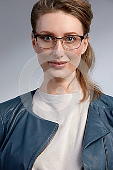 Beautiful young caucasian businesswoman studio shot on grey background. Charming and confident serious blond woman in