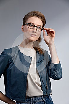 Beautiful young caucasian businesswoman studio shot on grey background. Charming and confident serious blond woman in