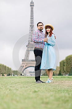 Beautiful young Caucasian couple, pretty red haired woman in blue dress and handsome bearded man in checkered shirt