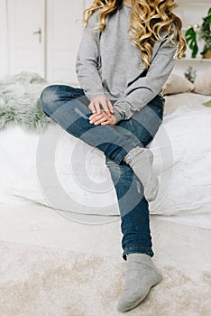 Beautiful young caucasian European woman casually sitting on the bed