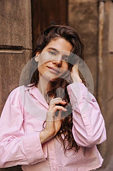 Beautiful young caucasian girl looking at camera tender posing at street during spring day.