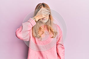 Beautiful young caucasian girl wearing casual clothes covering eyes with hand, looking serious and sad