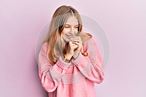 Beautiful young caucasian girl wearing casual clothes laughing nervous and excited with hands on chin looking to the side