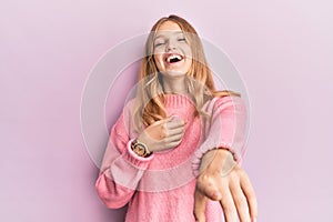 Beautiful young caucasian girl wearing casual clothes laughing at you, pointing finger to the camera with hand over body, shame