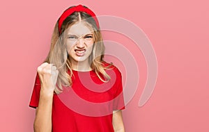 Beautiful young caucasian girl wearing casual red t shirt angry and mad raising fist frustrated and furious while shouting with