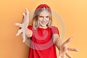 Beautiful young caucasian girl wearing casual red t shirt looking at the camera smiling with open arms for hug